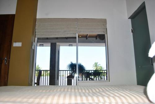 a bedroom with a window with a view of the ocean at The Canoe in Negombo
