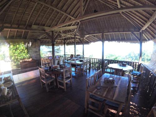 a restaurant with wooden tables and chairs in a room at Rinjani Mountain Garden in Bayan