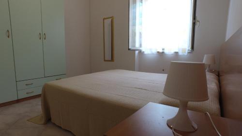 a bedroom with a bed and a lamp on a table at International Camping Village in Praia a Mare