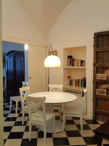 パレルモにあるCalamarùのチェッカーフロアの客室で、テーブルと椅子が備わります。
