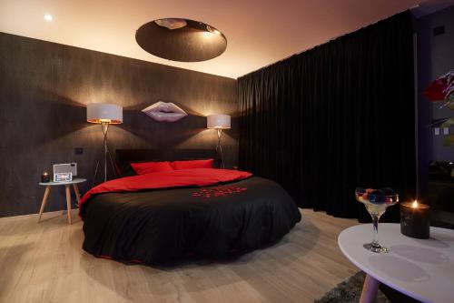 een slaapkamer met een bed met rode kussens en 2 lampen bij Crystal Love Appart in Pornichet