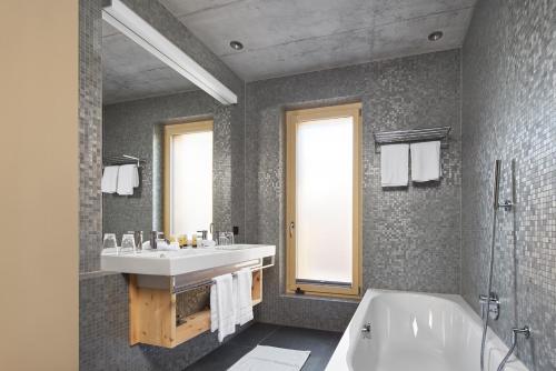 a bathroom with a sink and a bath tub at Alpine Lodge Chesa a la Punt in Pontresina