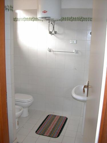 ポルトフェッラーイオにあるEda Houseの白いバスルーム(トイレ、シンク付)