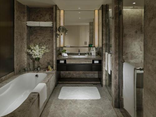 
a bathroom with a tub, sink, and mirror at Shangri-La Colombo in Colombo
