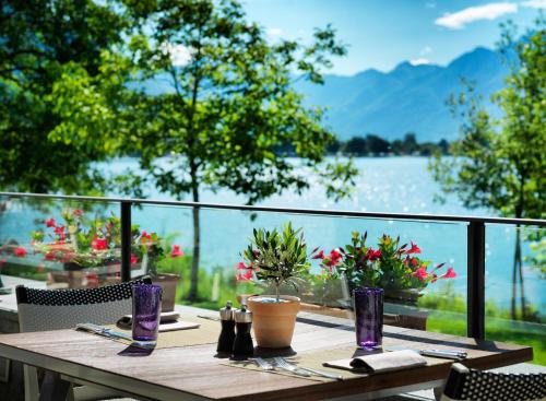 a wooden table with a view of a lake at Giardino Lago in Locarno