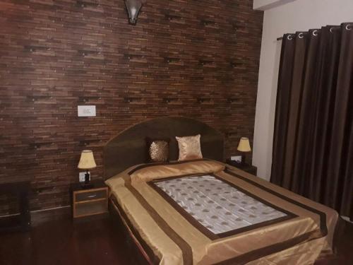 a bedroom with a large bed with a brick wall at Trimurti Pine Valley Resort in Shimla
