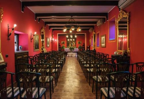 a row of chairs in a room with red walls at Convento Dei Riformati in Calopezzati