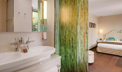 a bathroom with a sink and a shower and a bed at Giardino Lago in Locarno