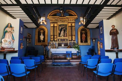 a room with blue chairs and a altar at Convento Dei Riformati in Calopezzati
