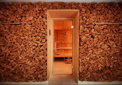 a room with a wall full of wood at Giardino Mountain in St. Moritz