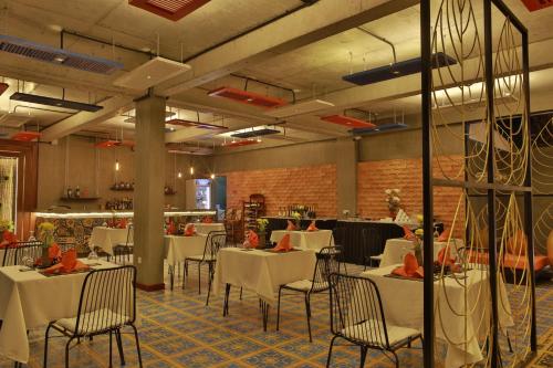 a dining room with white tables and chairs at Central Corner d'Angkor in Siem Reap