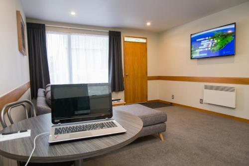 a room with a laptop sitting on a table at Dunedin Motel and Villas in Dunedin