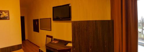 a bathroom with a sink and a tv on the wall at Non-stop Economy hotel in Boryspilʼ