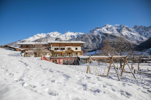 a house in the snow with mountains in the background at Ladestatthof in Neustift im Stubaital