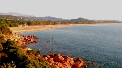 a beach with a bunch of rocks in the water at La Corte Degli Ulivi in Cardedu