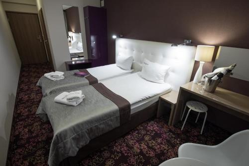a hotel room with two beds and a desk at Hotel Ameliówka in Masłów