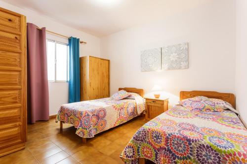 Un dormitorio con dos camas y una ventana en Vivienda Vacacional El Faro, en Puerto Naos, en Los Llanos de Aridane
