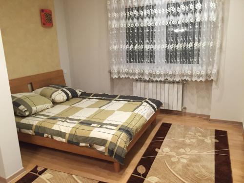 - une chambre avec un lit et une fenêtre avec des rideaux dans l'établissement Apartament Wilnianka, à Krynica-Zdrój