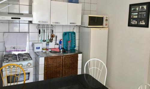 a kitchen with white cabinets and a white refrigerator at Flat em Sao Jose da Coroa Grande in São José da Coroa Grande