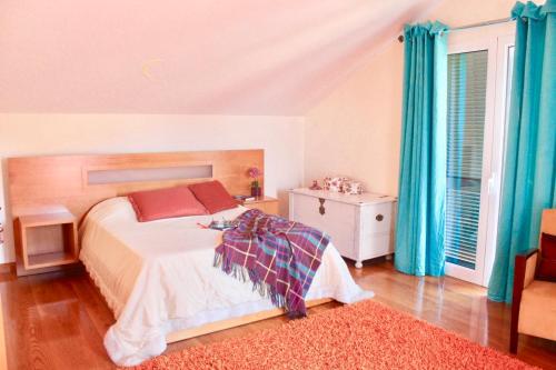 a bedroom with a bed and blue curtains at Pink House in Ponta do Sol