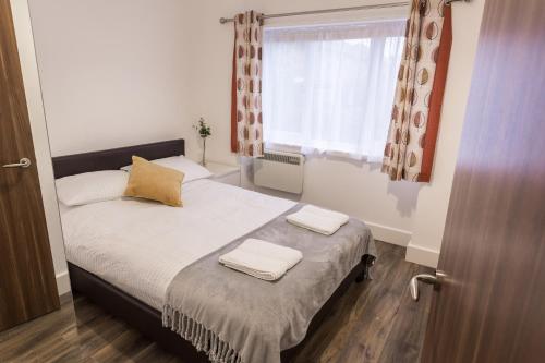 a small bedroom with a bed with two towels on it at Meridian Apartment Suites in Southend-on-Sea