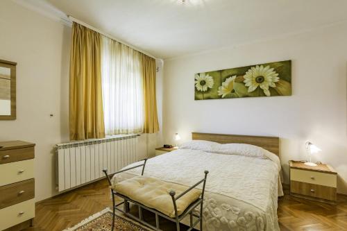 a bedroom with a bed and a painting on the wall at Apartment Kraljevic in Umag