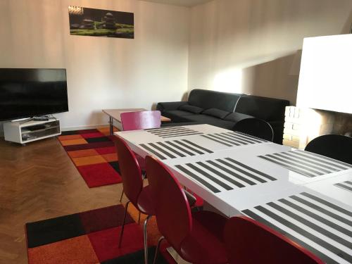 a living room with a table and chairs and a tv at Apartments Ålholmvej in Copenhagen