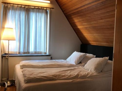 a bedroom with a large bed with a window at Apartments Ålholmvej in Copenhagen