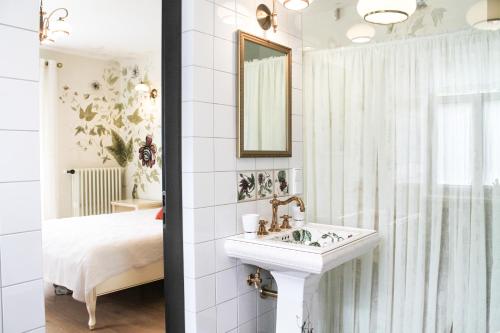 a white bathroom with a sink and a bed at Boutique Hotel Bersas in Turaida