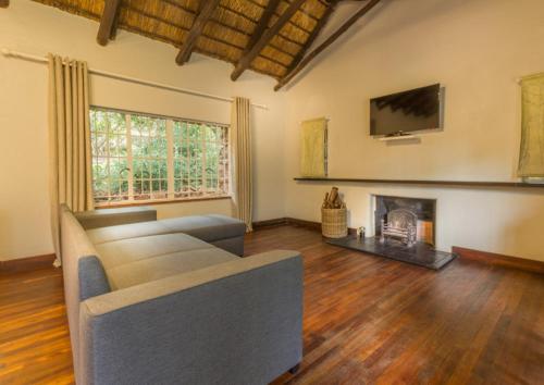 a living room with a couch and a fireplace at Pierneef's Kraal in Pretoria