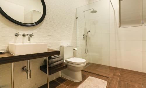 a bathroom with a toilet and a sink and a mirror at Valletta collection - Mint Suite in Valletta