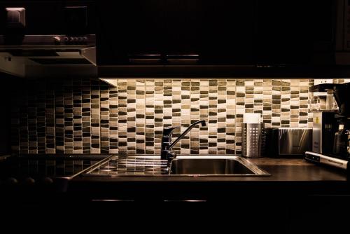 a kitchen counter with a sink and a tiled wall at Apartment Levi Star 1204 in Levi
