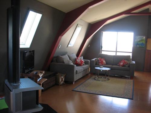 a living room with a couch and a tv at Barberry Hill in Stratford