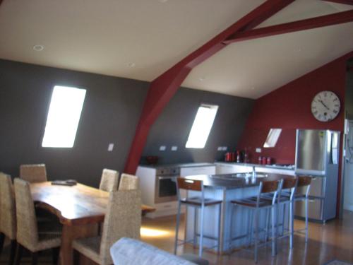 a kitchen and dining room with a clock on the wall at Barberry Hill in Stratford