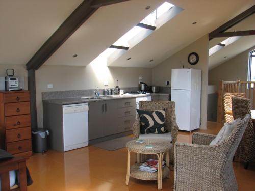 a kitchen with a white refrigerator and a table and chairs at Barberry Hill in Stratford