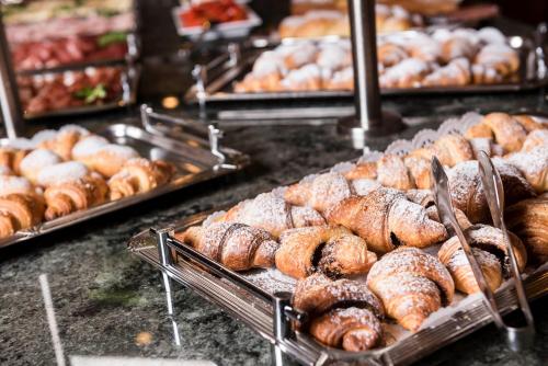 a bunch of pastries in trays in a bakery at Hotel Grüner Baum in Bressanone