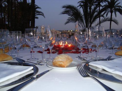 a table with wine glasses and a plate of food at Parador de Jávea in Jávea