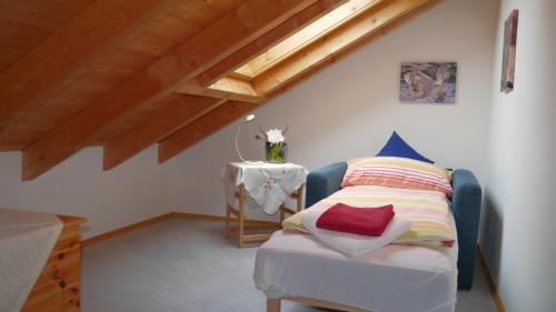 ein Schlafzimmer mit einem Bett und einem Tisch im Dachgeschoss in der Unterkunft Ferienwohnung Bodenmais am Silberberg in Bodenmais