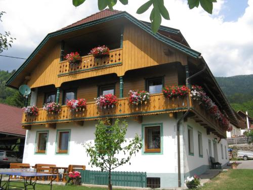 una casa con fiori sui balconi di Ortnerhof a Millstatt