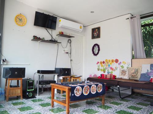 a living room with a couch and a table at Baan Sai Nam in Damnoen Saduak
