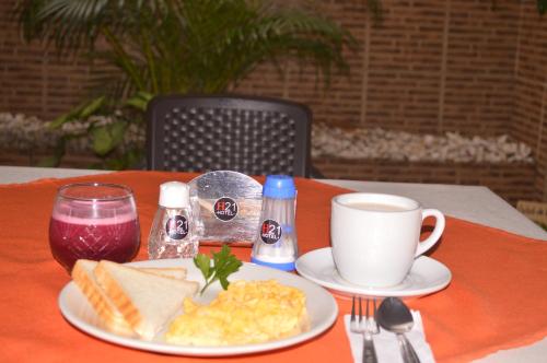uma mesa com um prato de ovos e uma chávena de café em Hotel H21 em Cali