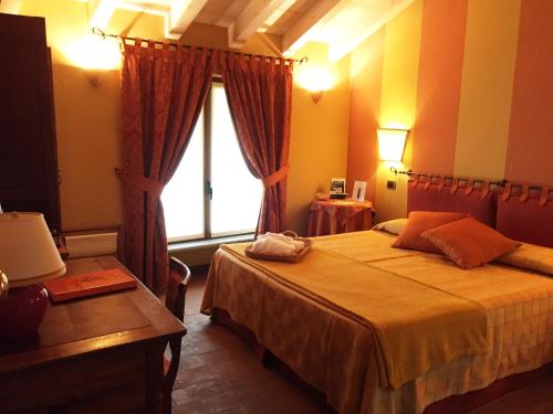 una camera con un grande letto e una finestra di Hotel Locanda Da Carla a Vigevano