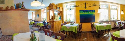 オーベルンブルク・アム・マインにあるLandgasthaus Römerhofのテーブルと椅子(緑のテーブルクロス付)が備わるレストラン