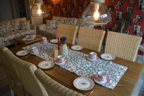a wooden table with plates and cups on it at Ferienappartements "Landromantik" in Bautzen