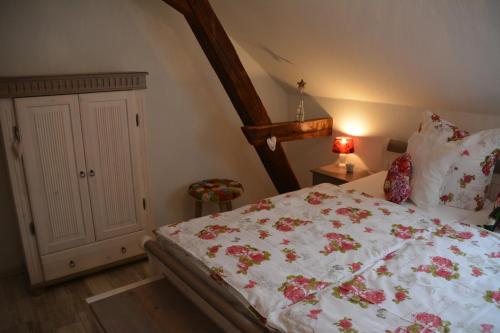 a bedroom with a white bed with flowers on it at Ferienappartements "Landromantik" in Bautzen