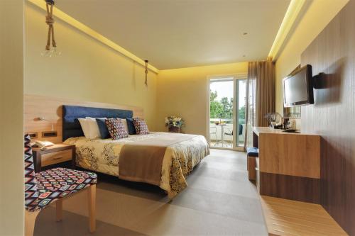 um quarto de hotel com uma cama e uma televisão em Congo Palace em Atenas