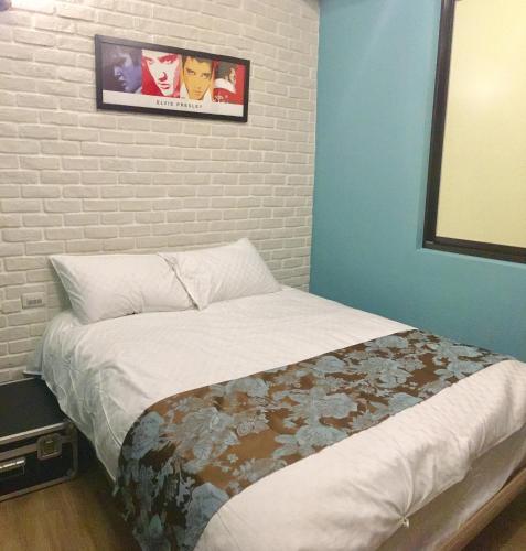 a bed in a room with a brick wall at Luck Homestay in Jiufen