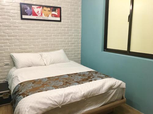 a bed in a room with a brick wall at Luck Homestay in Jiufen