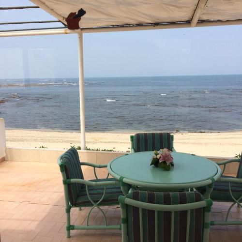 a table and chairs with a view of the beach at Cabanon Pied Dans L'eau in Mansouria