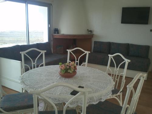 a living room with a table and chairs and a couch at Cabanon Pied Dans L'eau in Mansouria